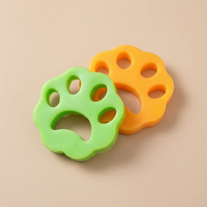 Lime green and orange paw-shaped cat hair removers overlapping on tan background
