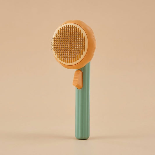 Sage green and orange pumpkin-style cat brush upright with metal slicker bristles