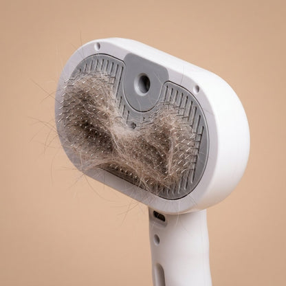 Close-up of white steam grooming brush head with shed cat hair caught in metal bristles