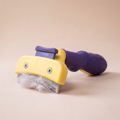 Purple handle cat detangler showing release lever on yellow comb head