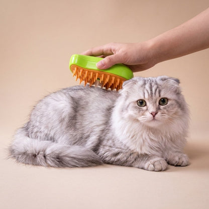 Hand holding a lime green steamy brush on a fluffy grey cat head and shoulders