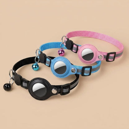 Black blue and pink AirTag cat collars angled diagonal on tan background